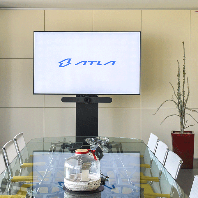 A room with a glass table and TV screen